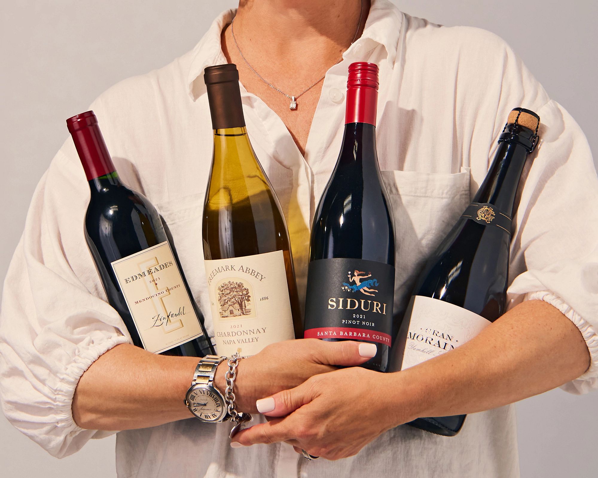 A person holding 4 bottles of wine