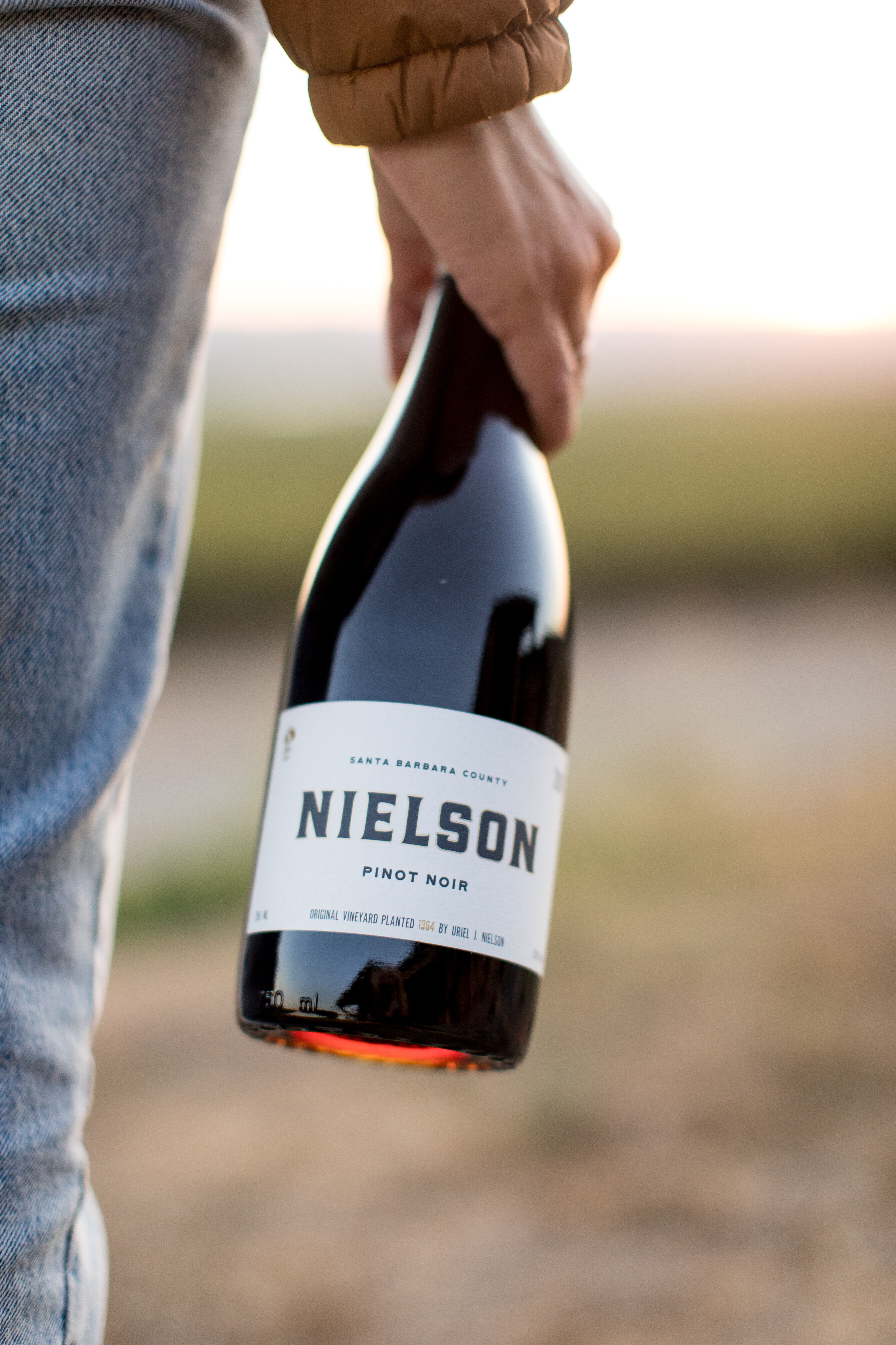 Person holding bottle of wine.
