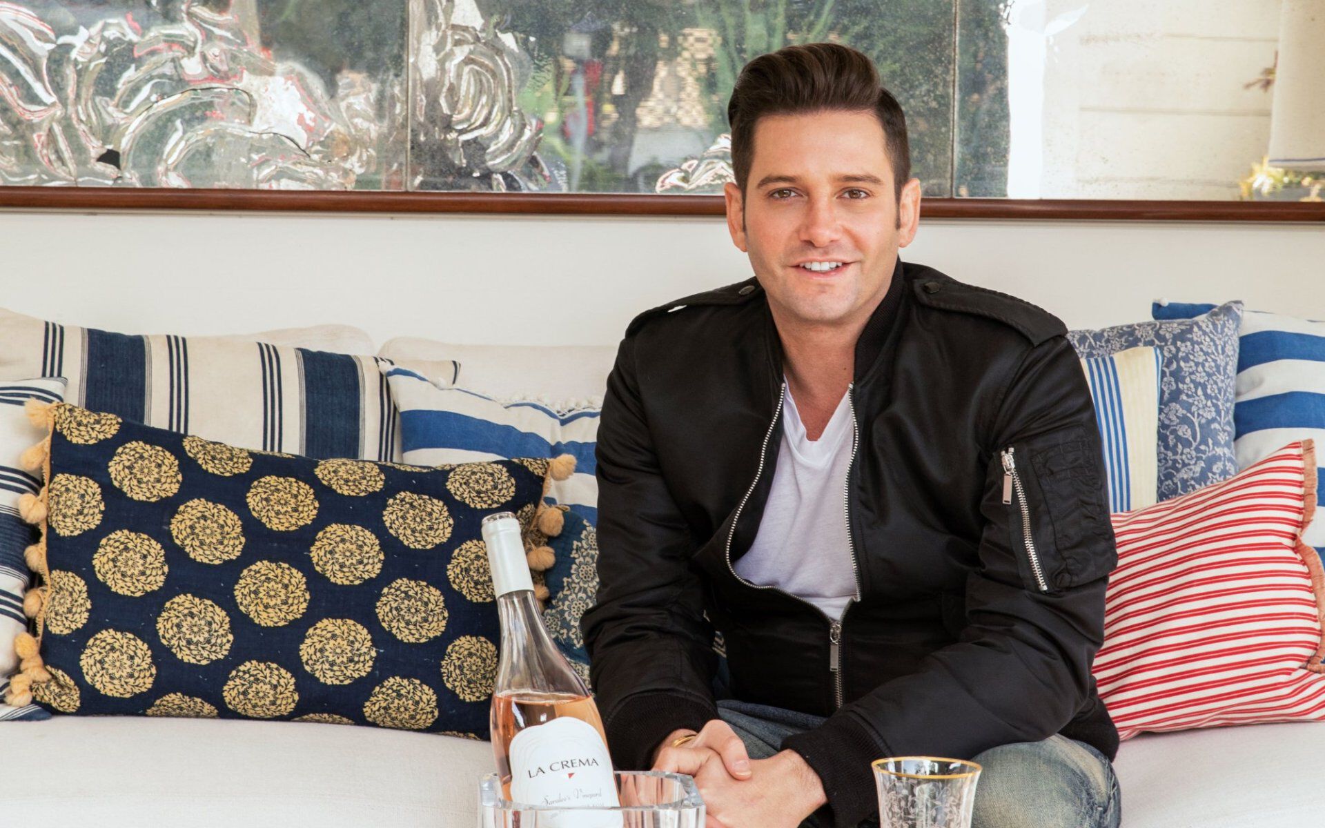 Josh Flagg sitting with wine in ice bucket on table in front of him.