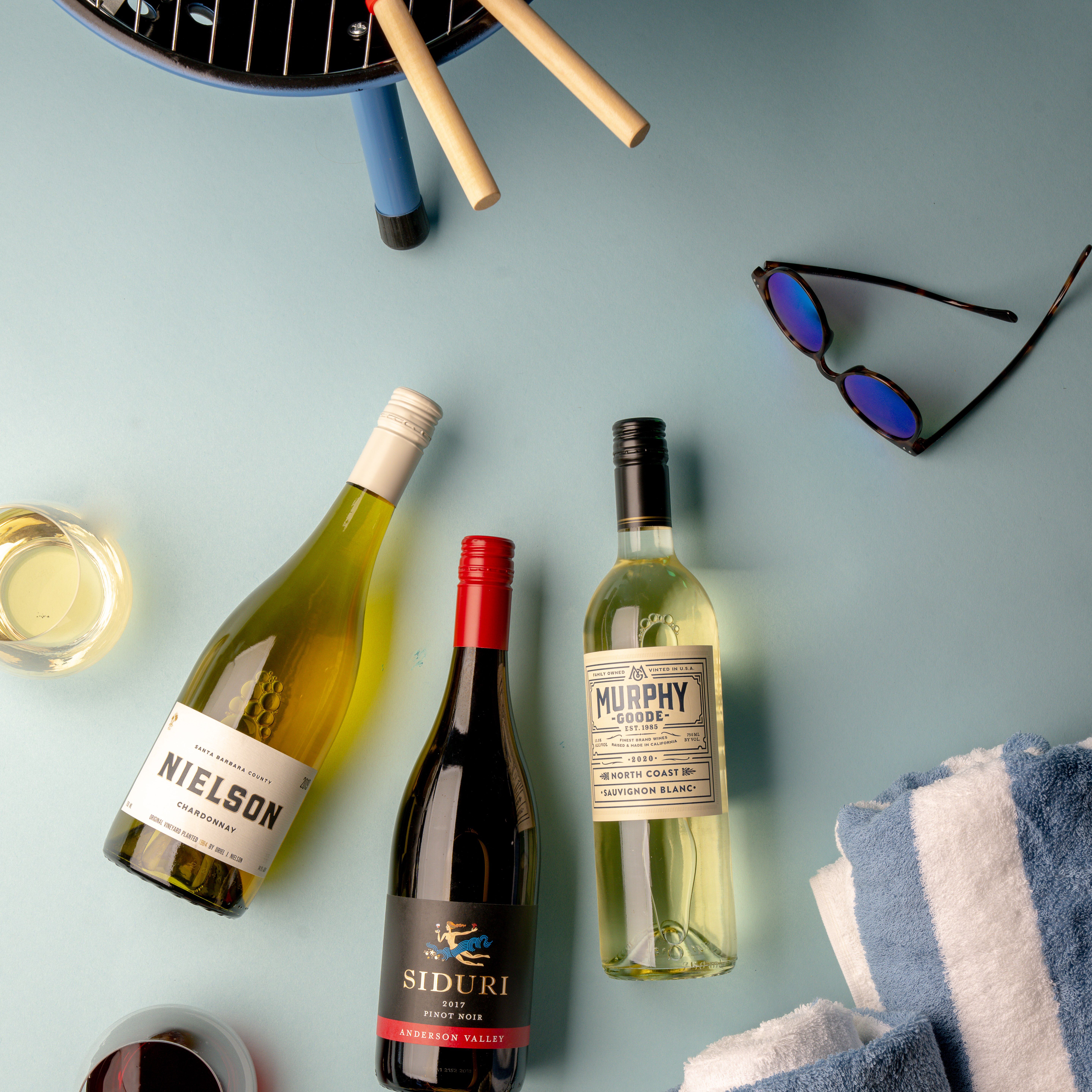 Three wines with towel and sunglasses.