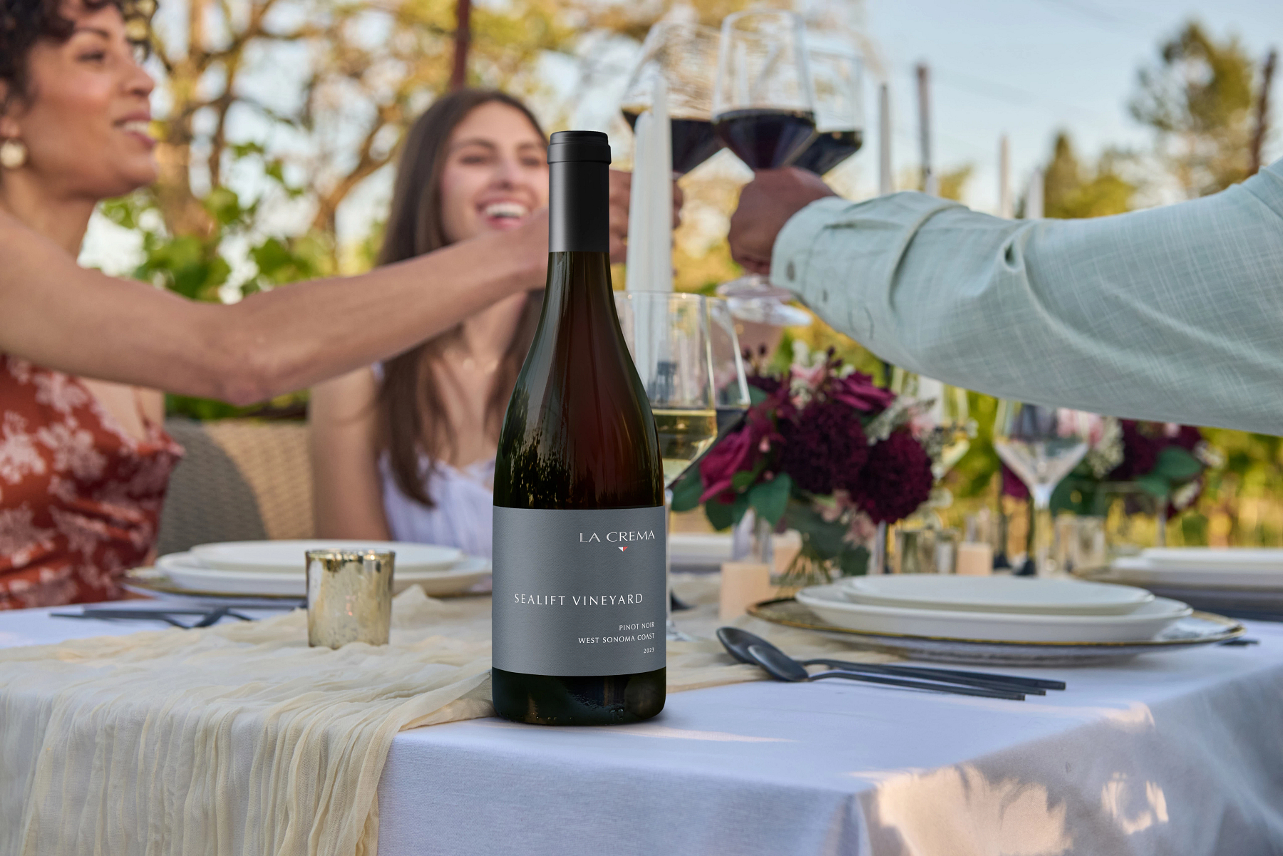 Friends enjoying a dinner outside with La Crema wine